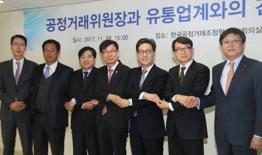 김상조 공정거래위원장(왼쪽 네번째)이 29일 서울  대한상공회의소에서 유통업계 대표들과 간담회를 하기 전 기념촬영을 하고 있다. 왼쪽부터 이갑수 체인스토어협회 회장, 이근협 TV홈쇼핑협회 부회장, 김도열 면세점협회 이사장, 김 위원장, 조윤성 편의점산업협회 회장, 박동운 백화점협회 회장, 김형준 온라인쇼핑협회 부회장.  연합뉴스